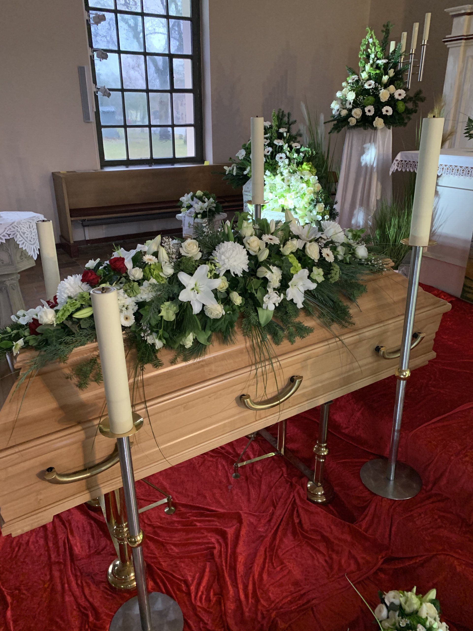 Weißer Sargschmuck mit Lilien und festlicher Trauerdekoration von Blumen Sprockhoff Seelow