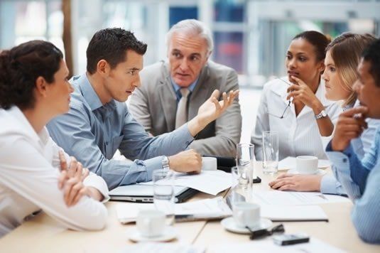 Incontro di mediazione civile con uomo business centrale che parla a donne e uomini in incontro di lavoro