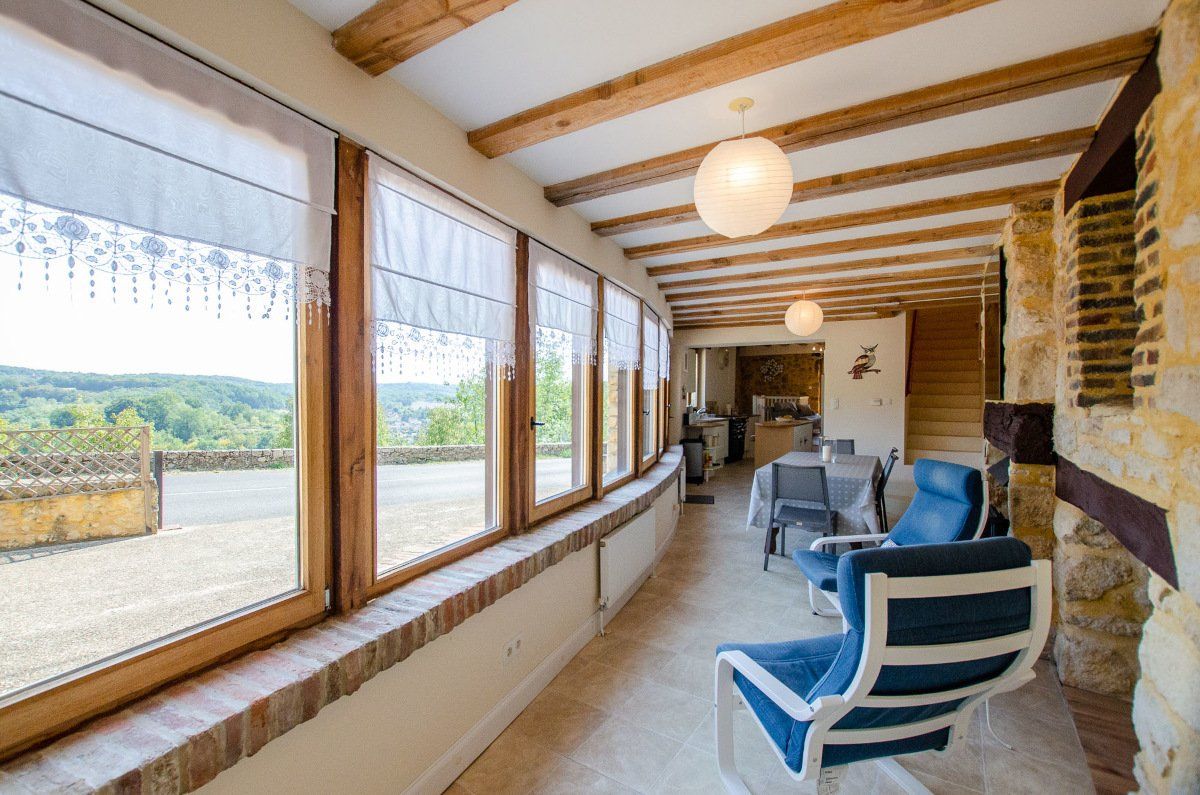 Véranda lumineuse du gîte La Perle Noire avec vue sur la vallée du Périgord Noir