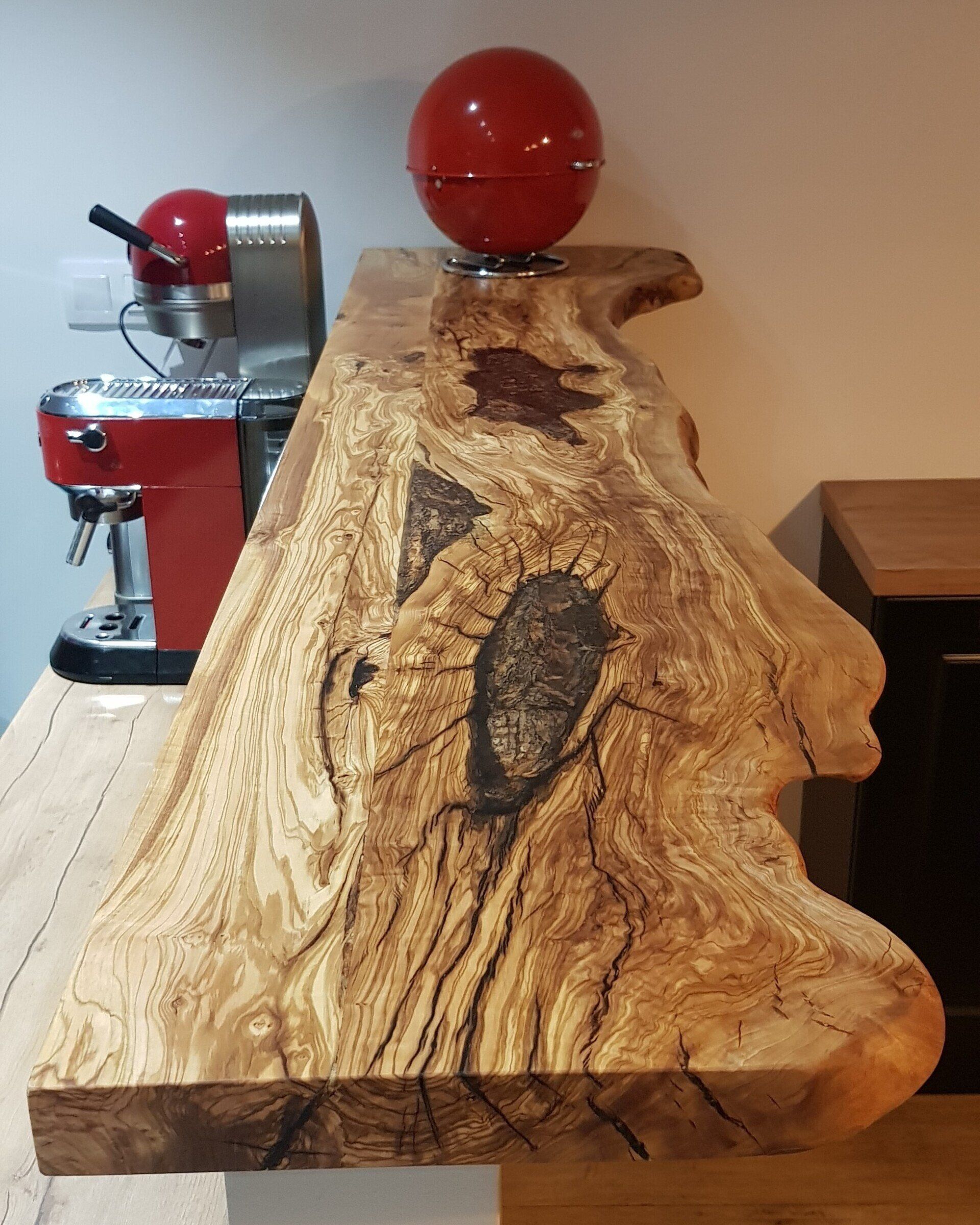 Dessus de bar en bois massif d'olivier. Veinage marqué avec insertion de résine époxy transparente.