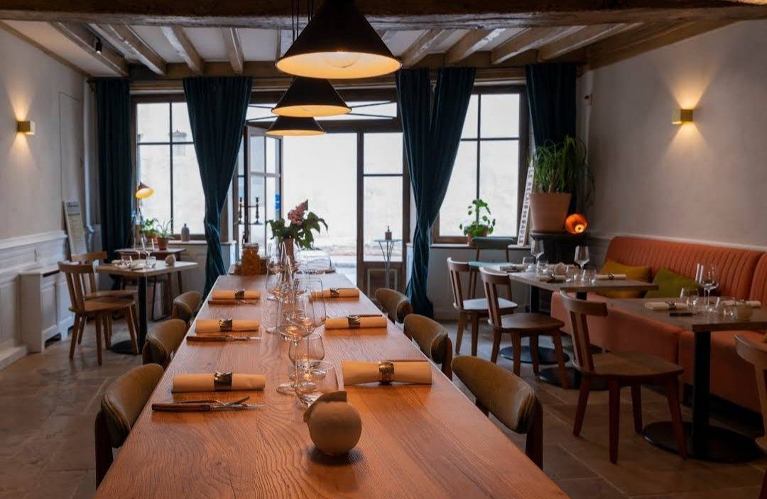 Table en frêne olivier massif, ici dans un restaurant. Mobilier qualitatif