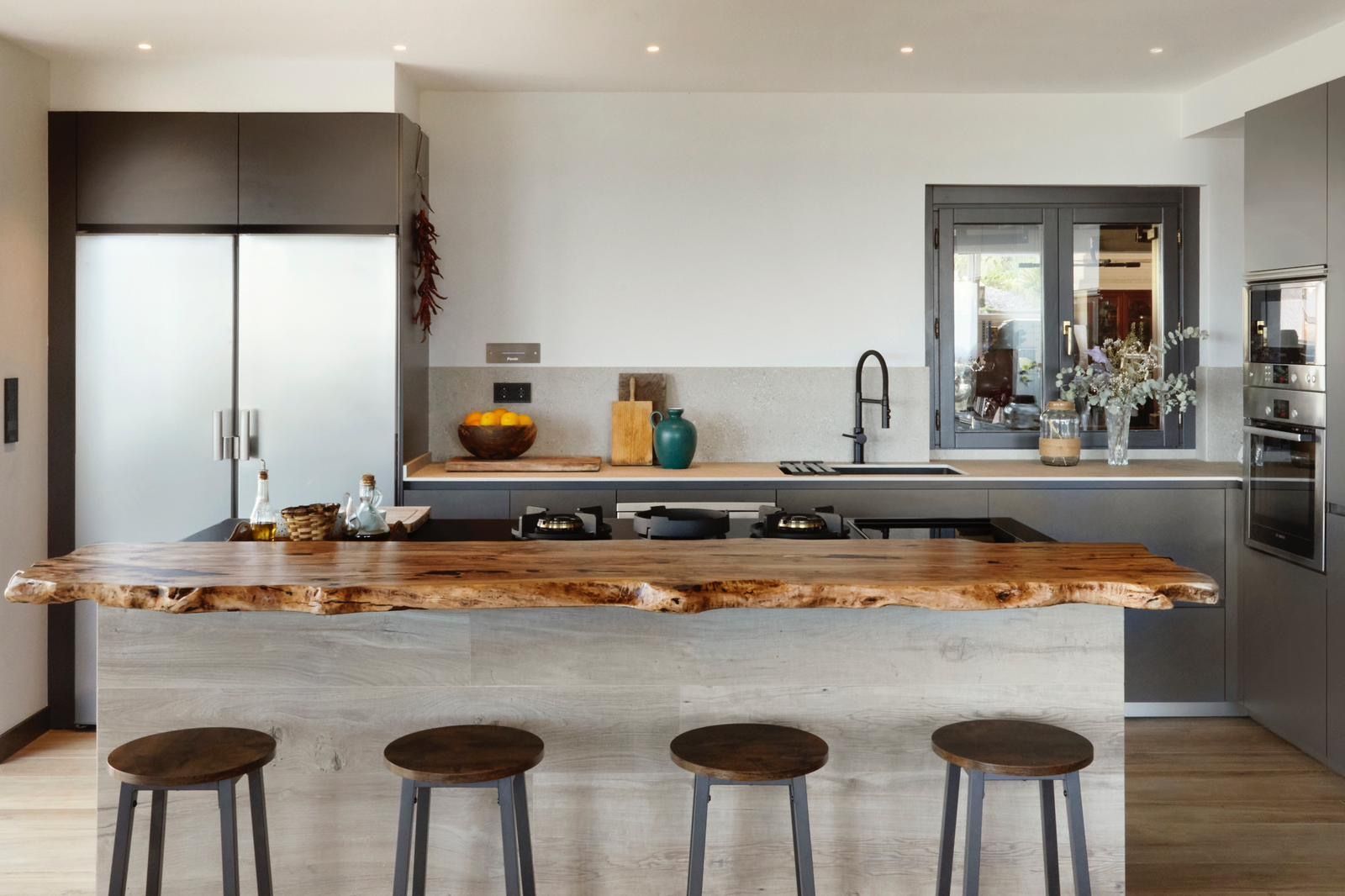 Plan de travail en olivier massif sur mesure pour une cuisine moderne plus chaleureuse.