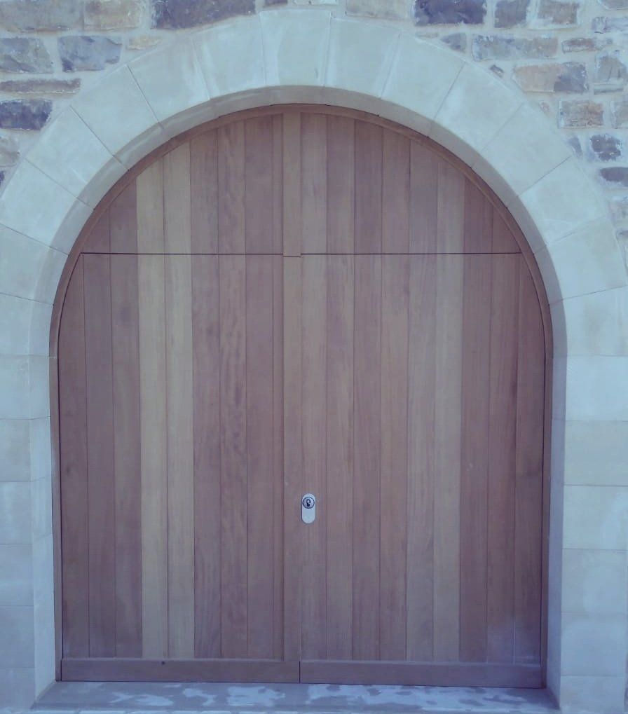 Rénovation de porte de grange voutée en bois massif.