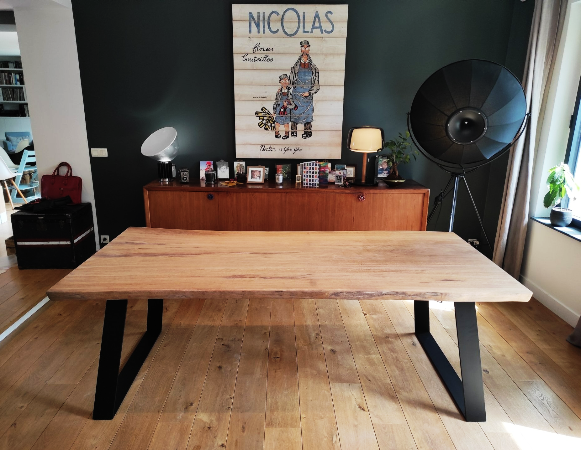Table en iroko massif avec ses deux pieds U en acier noir. Bords naturels live edge.