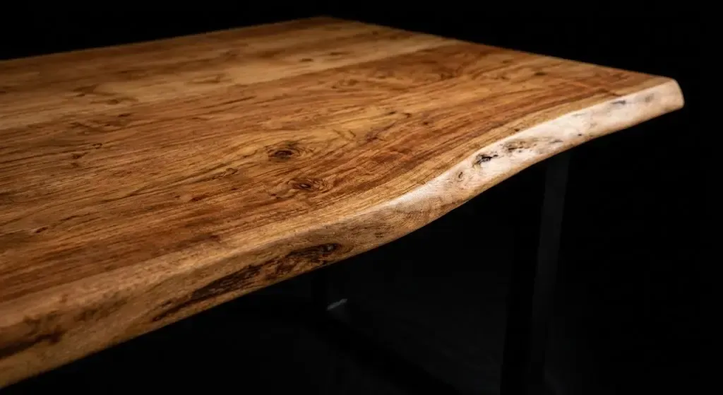 Zoom sur le veinage naturel et les finitions d'un plateau de table en acacia massif.