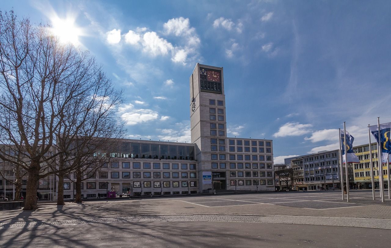 Das Bild zeigt das Rathaus Stuttgart unter einem sonnigen blauen Himmel.