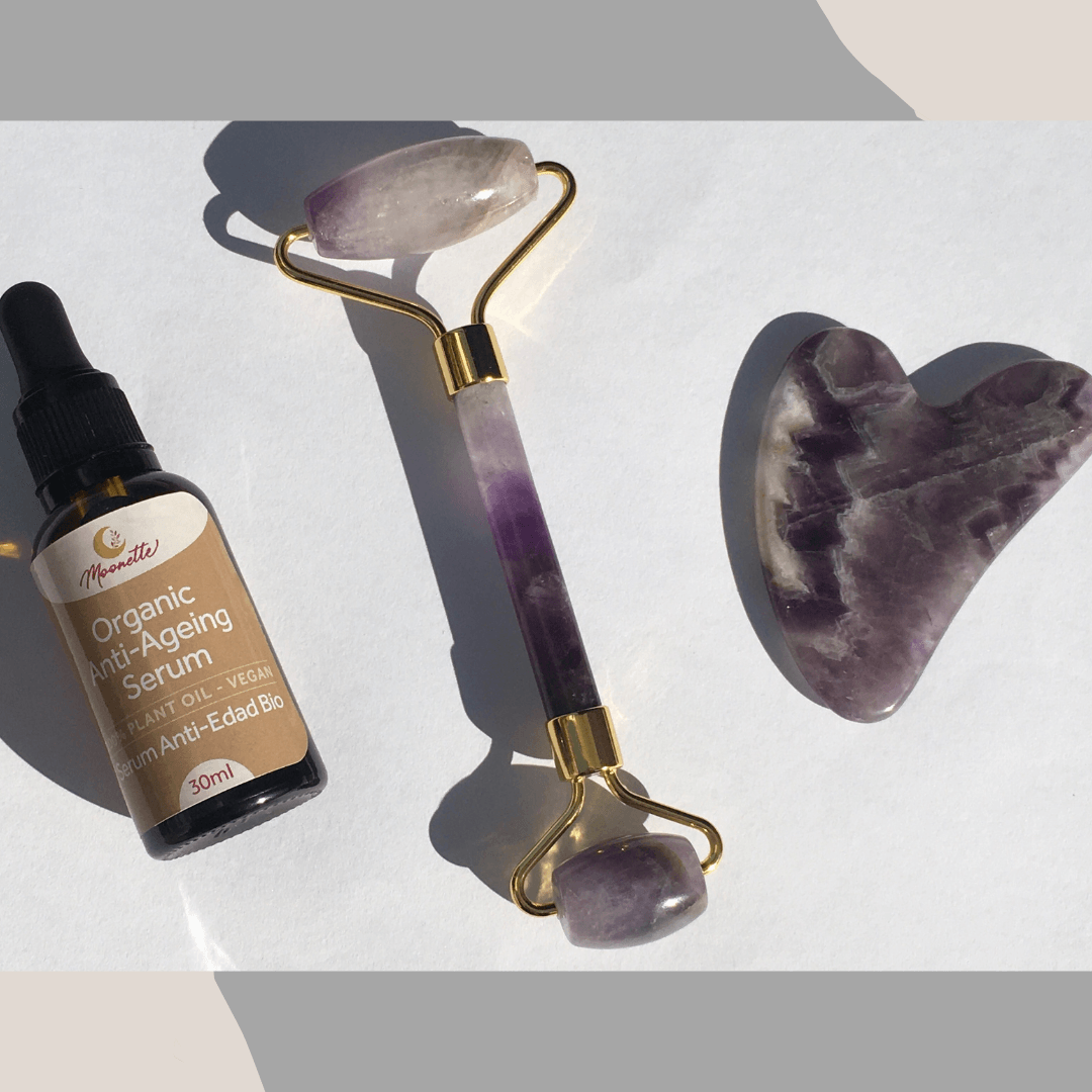 A bottle of anti-aging serum, an amethyst jade roller and gua sha.
