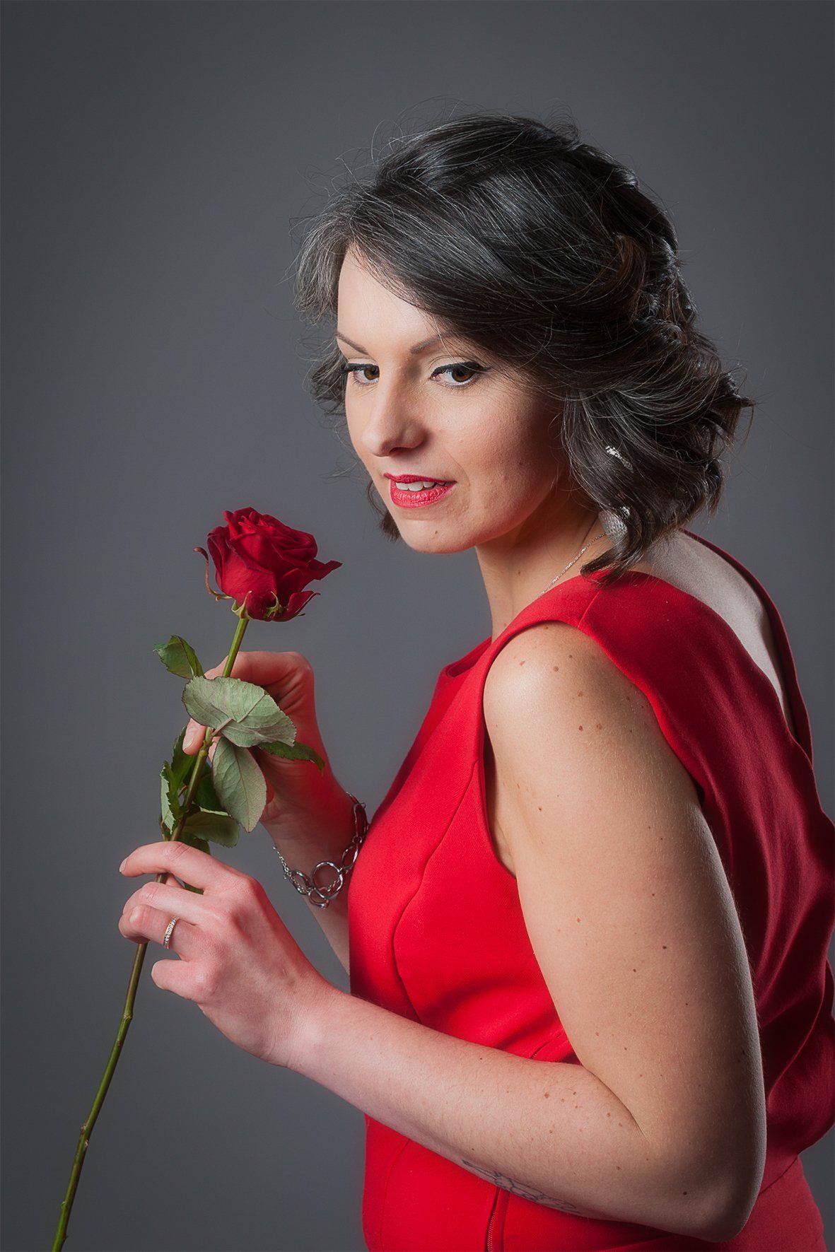 femme en robe rouge avec une rose