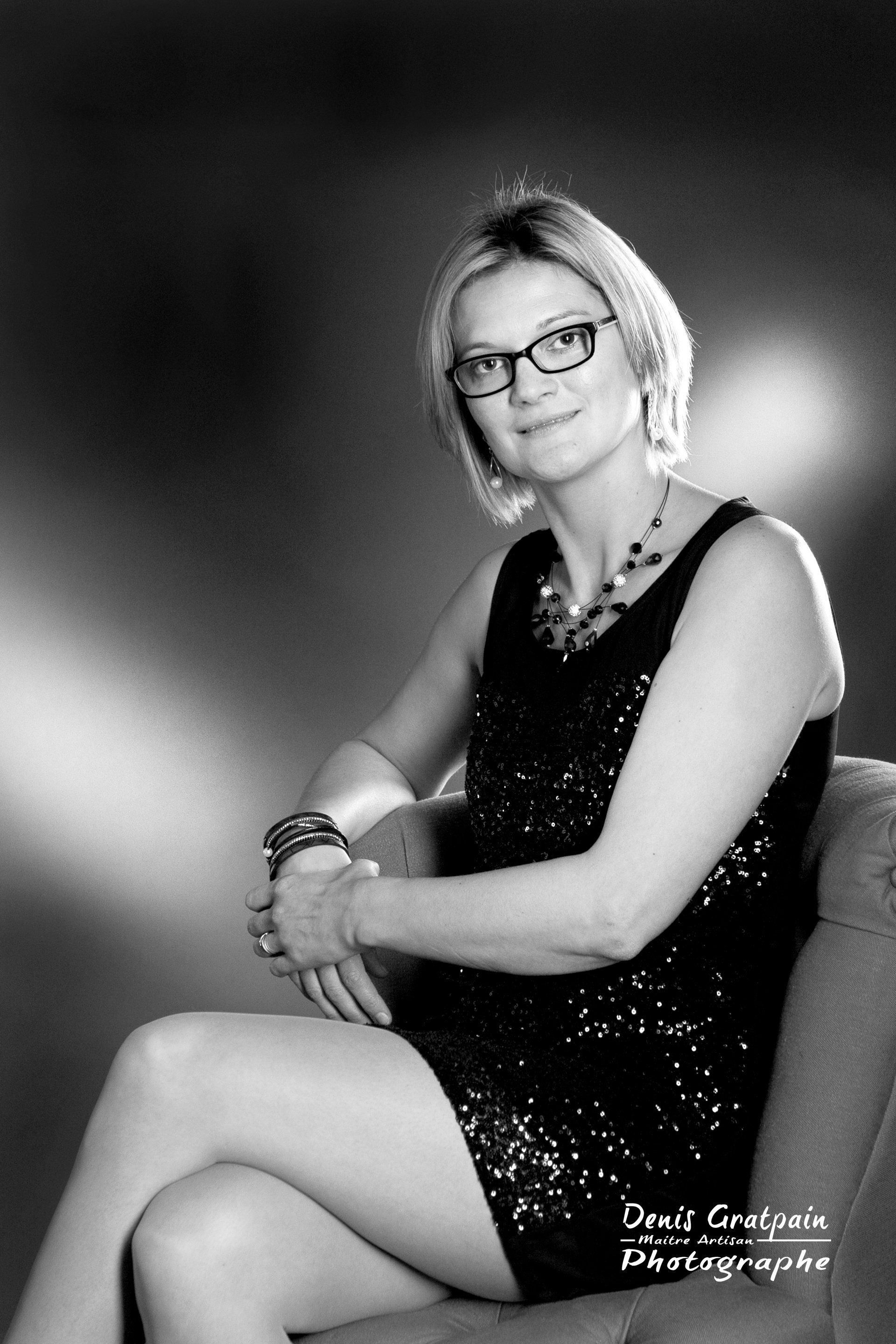 Femme avec des lunettes assise en noir et blanc