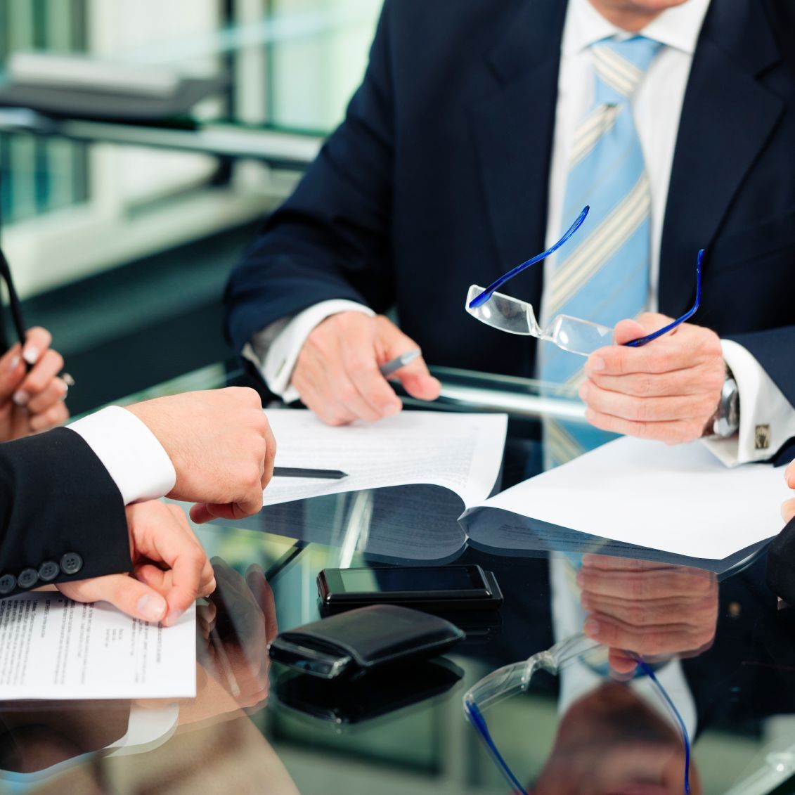 2 Herren sitzen am Glastisch und haben eine Besprechung