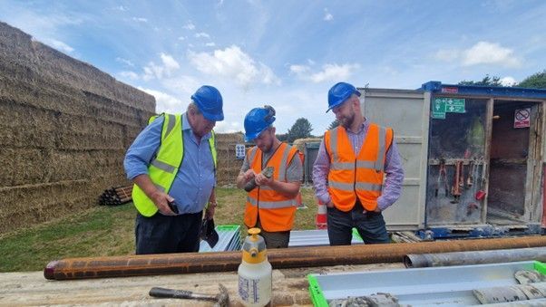 Three men, Director Charles Manners (left), Senior geologist Rowan Thorne (centre) and senior geologist and project manager Dennis Rowland (right) stand within the drill rig compound and discuss core extraction