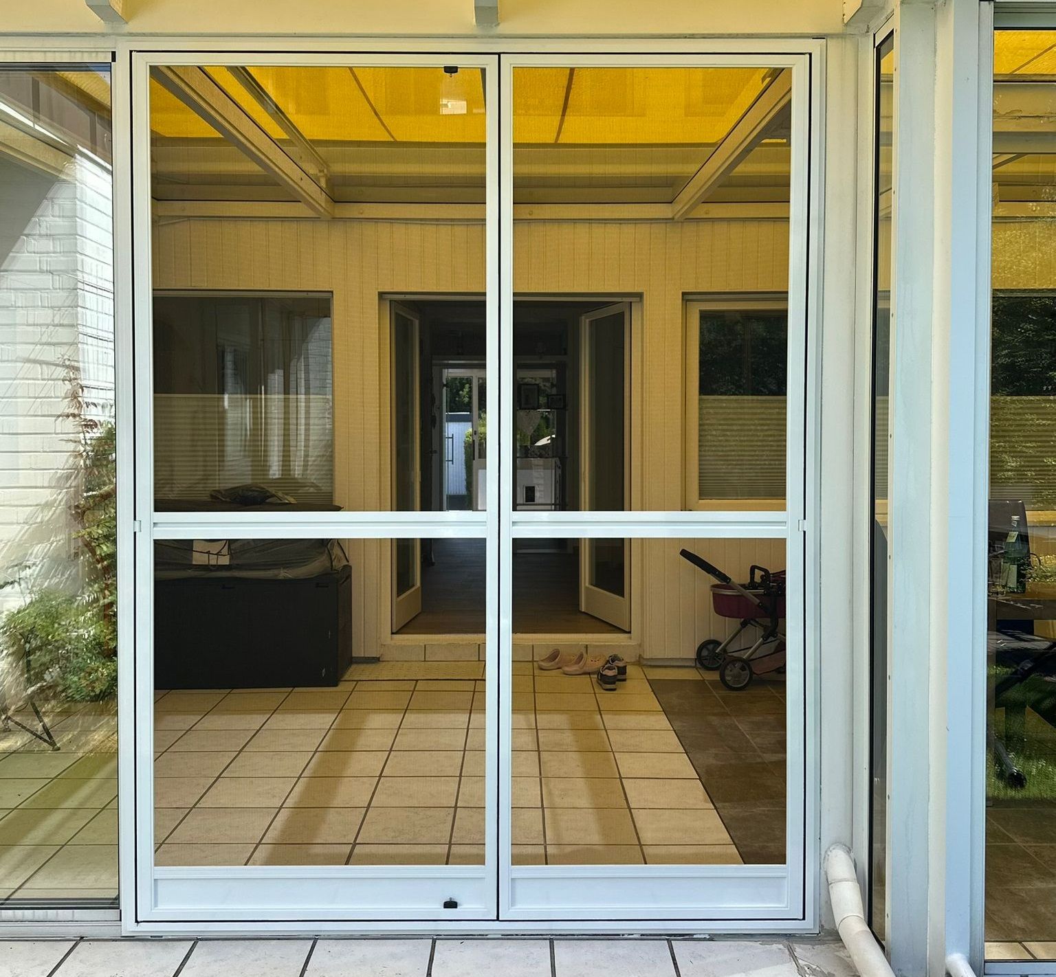 Insektenschutz-Doppelpendeltür mit weißem Aluminiumrahmen für Wintergarten oder breite Terrassentür – beidseitig öffnend und komfortabler Durchgang