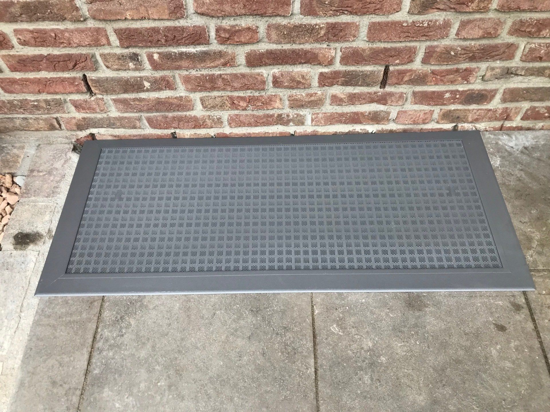 Cubierta transitable para pozo de luz de aluminio con malla fina, integrada a ras en la terraza