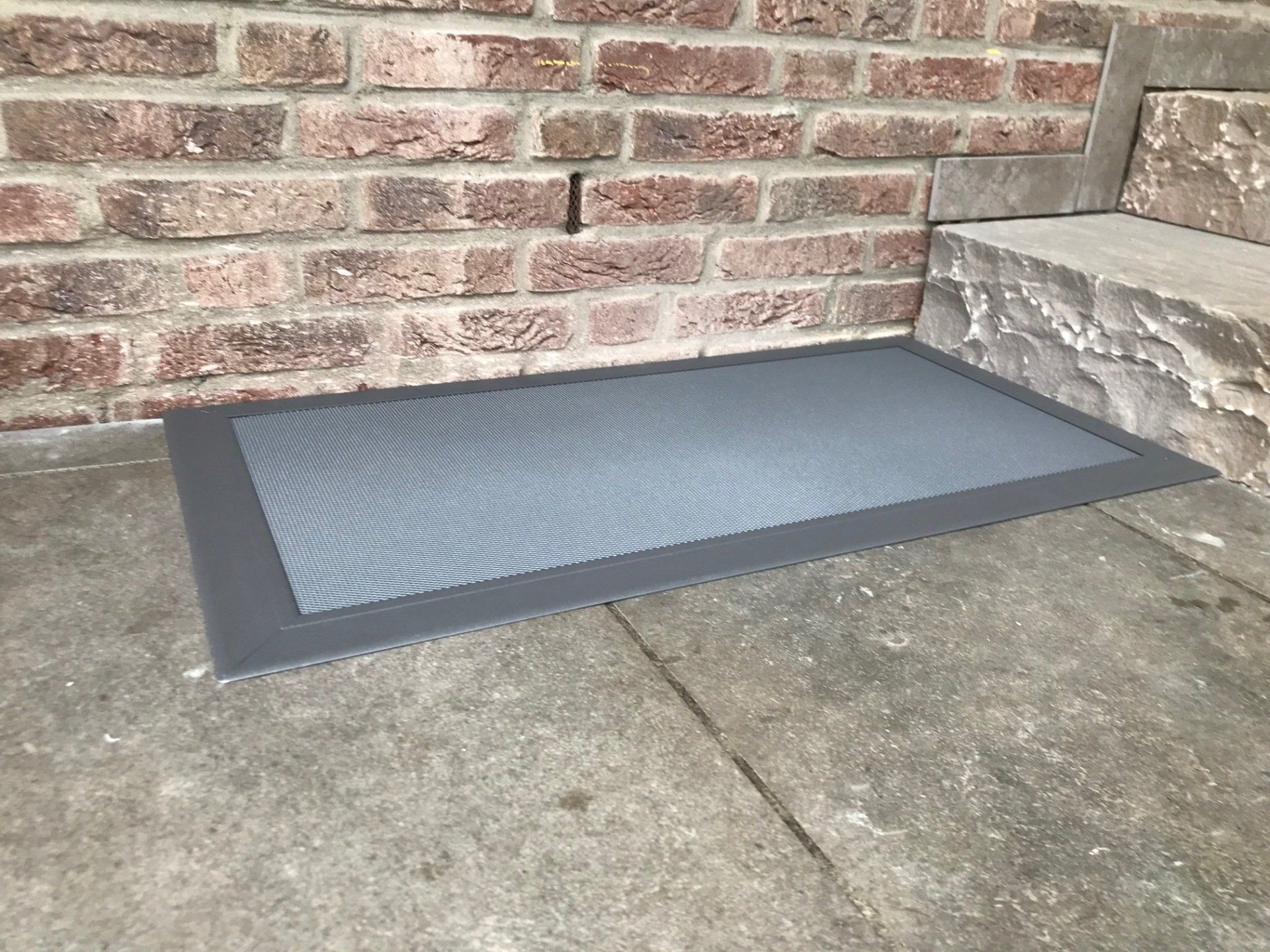 Begehbare Lichtschachtabdeckung aus Aluminium mit feinmaschigem Gitter, flächenbündig in der Terrasse montiert