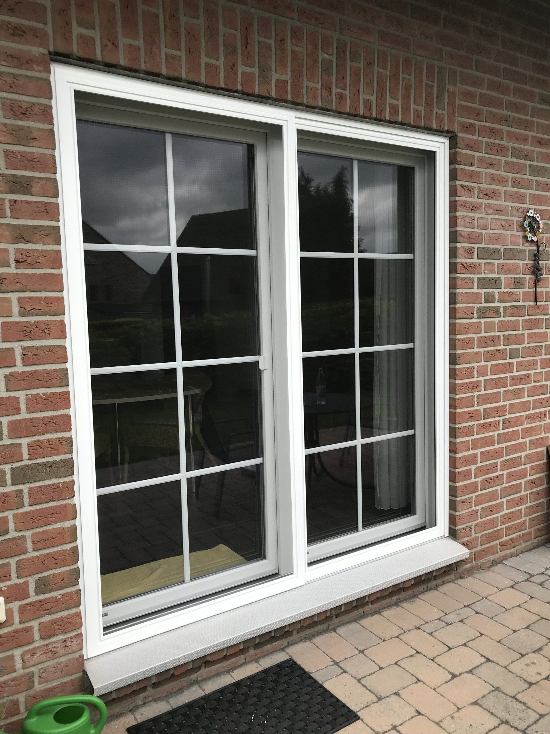 Puerta mosquitera corredera doble con marco de aluminio blanco para terrazas amplias – hojas deslizantes a ambos lados y protección eficaz contra insectos