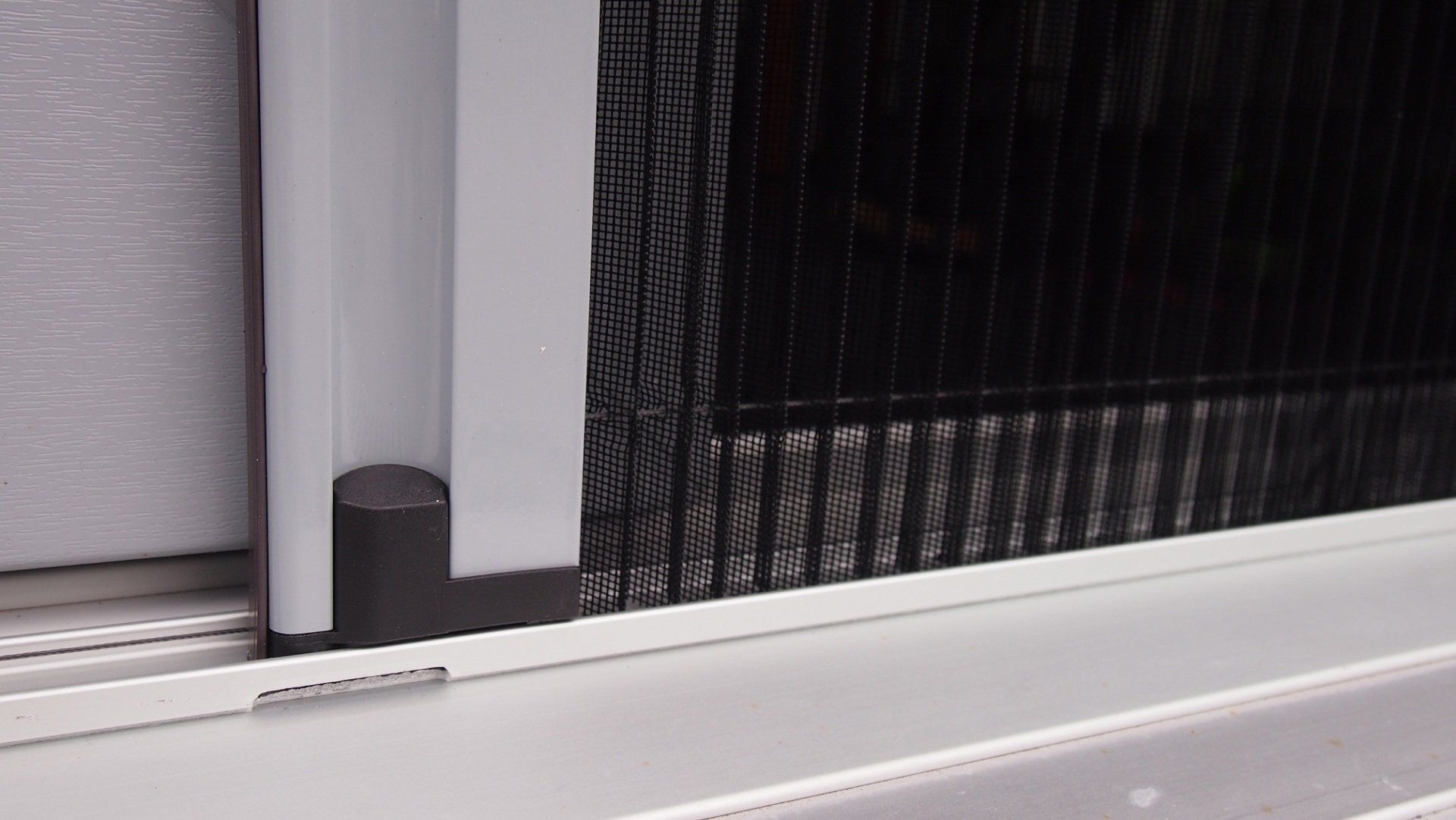 Detail view of a custom-made pleated insect screen door with flat bottom track – low-threshold, stable and discreetly integrated