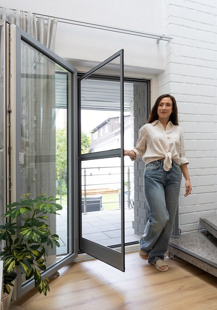 Geöffnete Balkontür mit maßgefertigtem Insektenschutz – komfortables Lüften im Wohnbereich