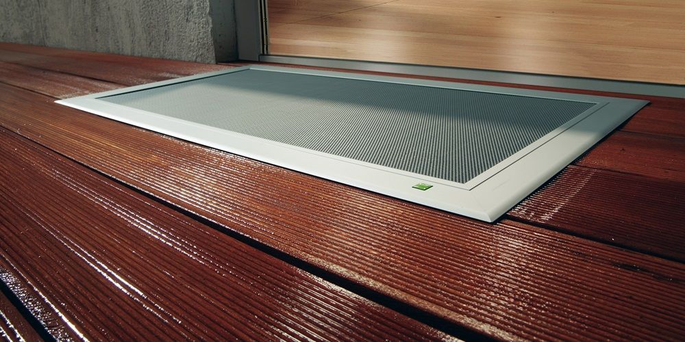 Flat window well cover with insect screen integrated into a wooden terrace