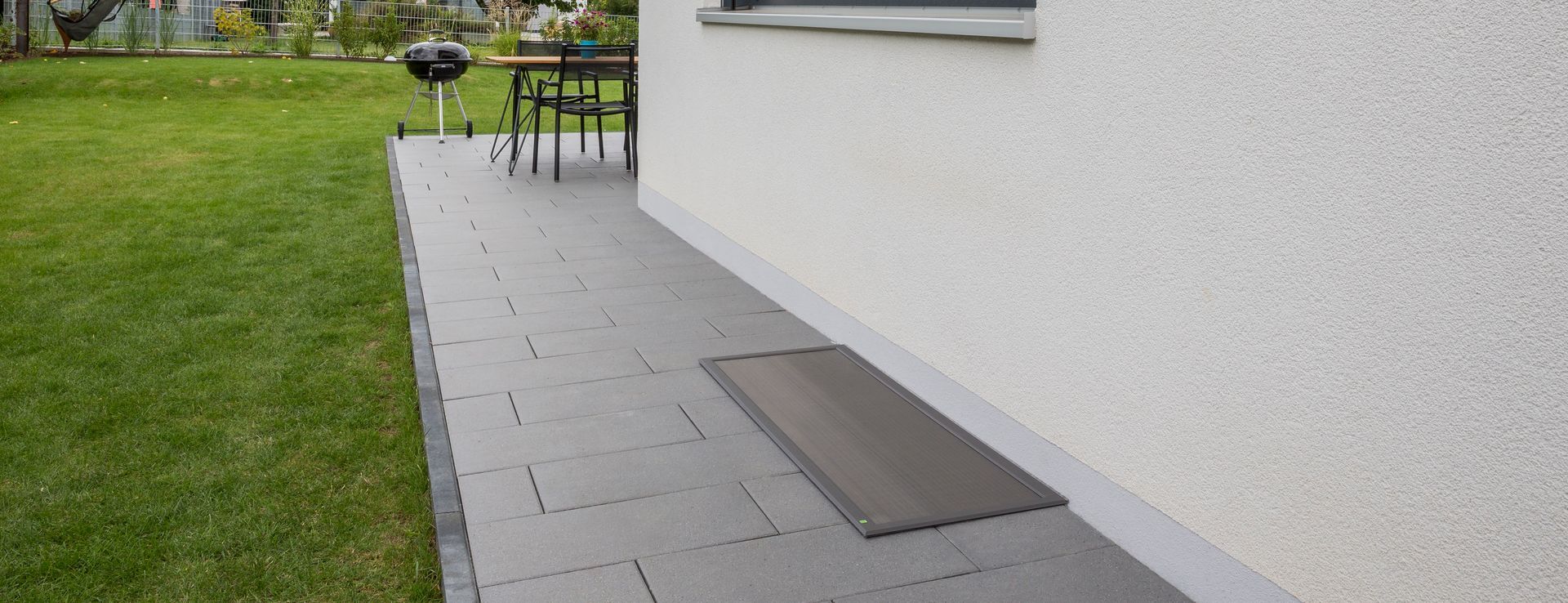 Flächenbündig eingebaute Lichtschachtabdeckung „Lisa“ von Neher – begehbar, unauffällig integriert im Terrassenbereich.