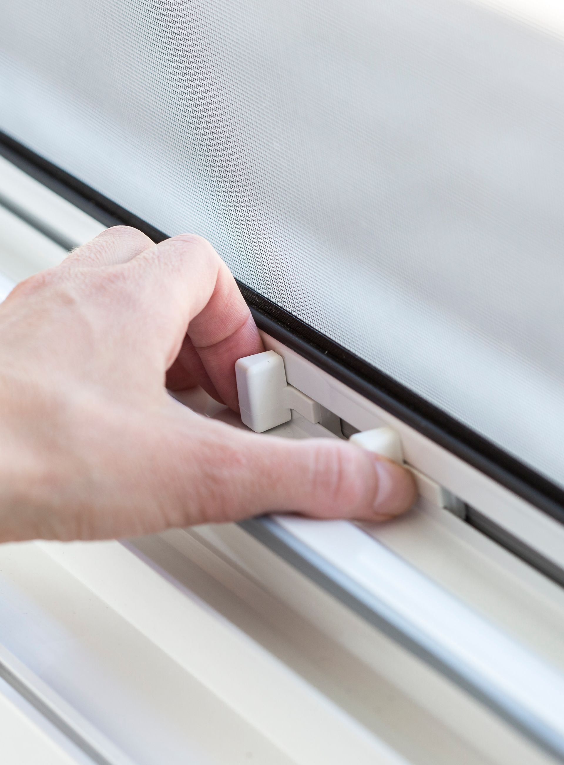 Detailansicht eines Insektenschutz-Rollos für Fenster von ISK Systeme mit feinmaschigem Gewebe und arretierbarer Führungsschiene – komfortable Bedienung und zuverlässiger Schutz vor Insekten.