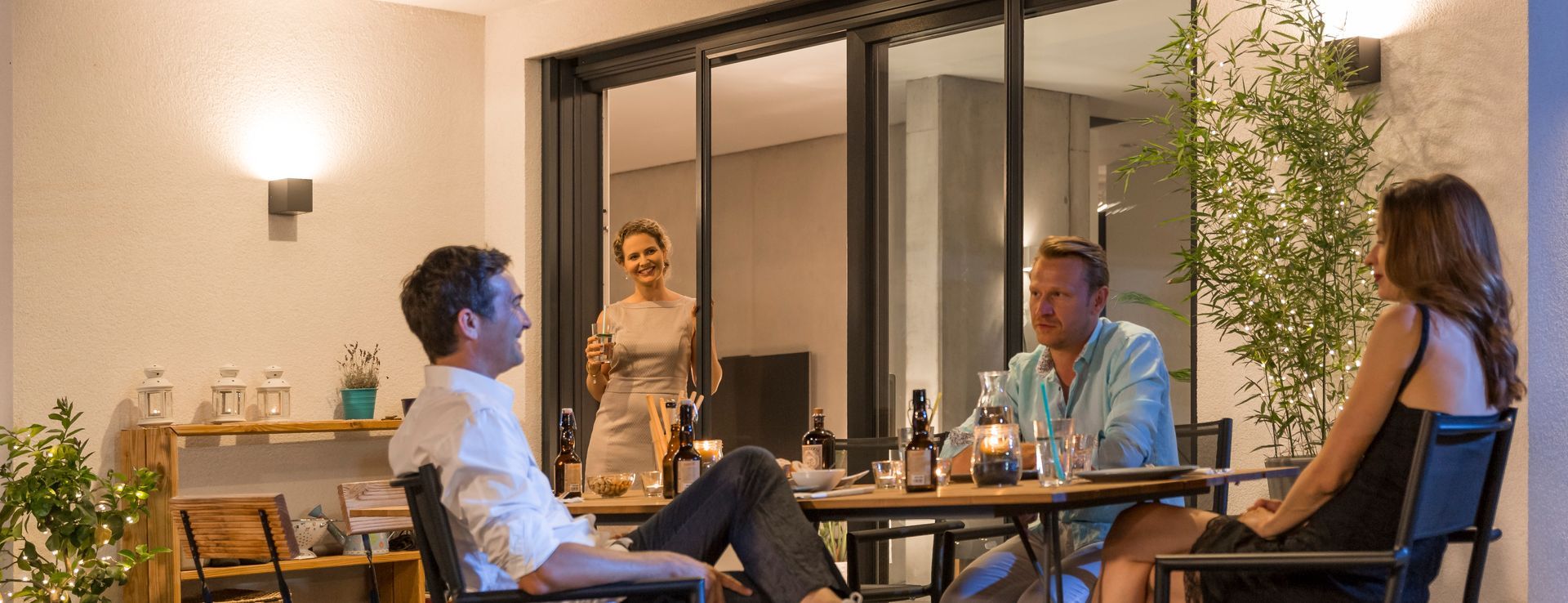 ISK Systeme Insektenschutz-Pendeltür an einer großen Terrassentür ermöglicht ungestörtes Zusammensitzen im Außenbereich bei geöffneten Türen und hält Insekten zuverlässig fern.