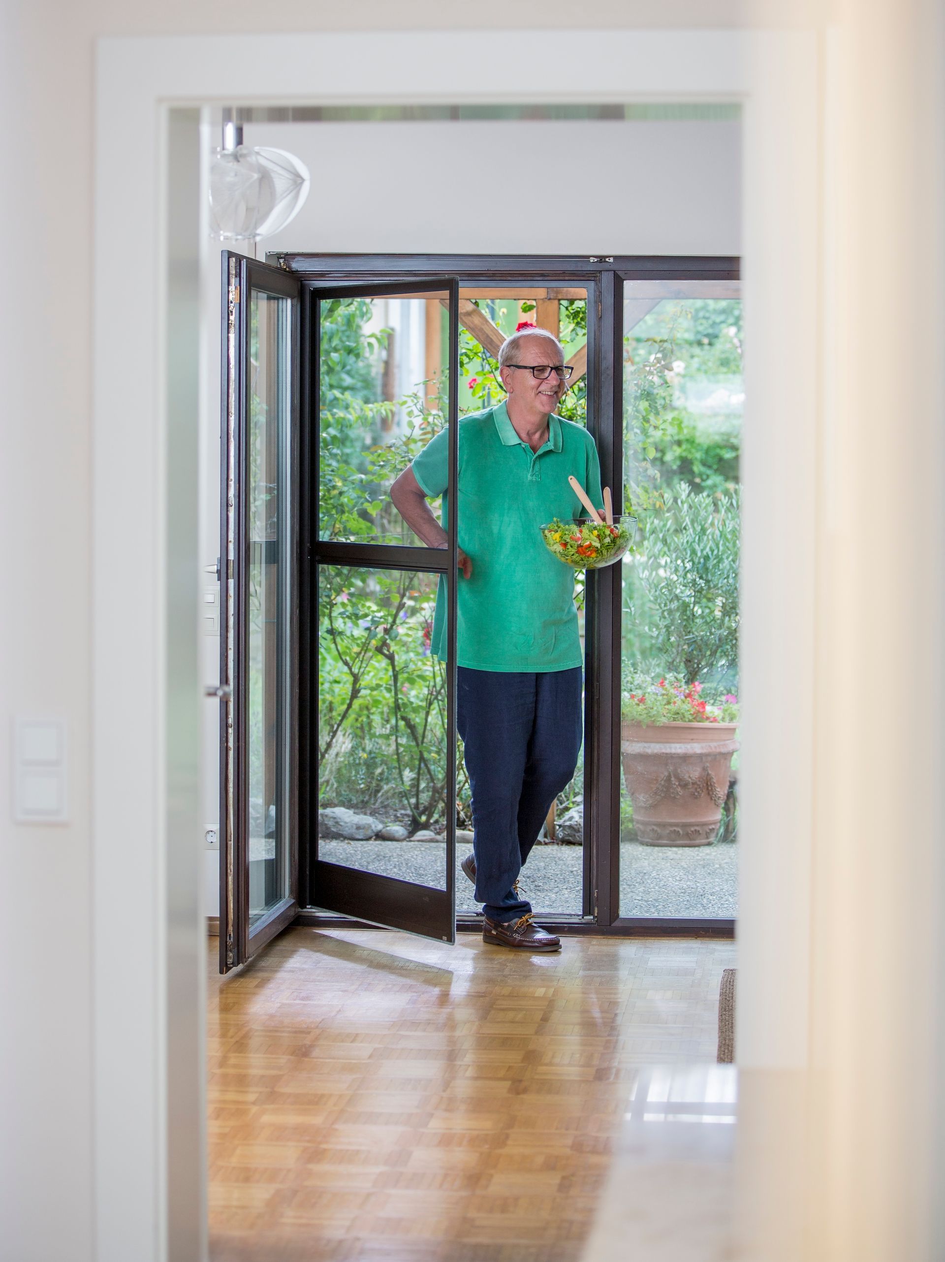 Maßgefertigte ISK Systeme Insektenschutz-Pendeltür an einer Terrassentür, komfortabler Durchgang mit freihändiger Bedienung.