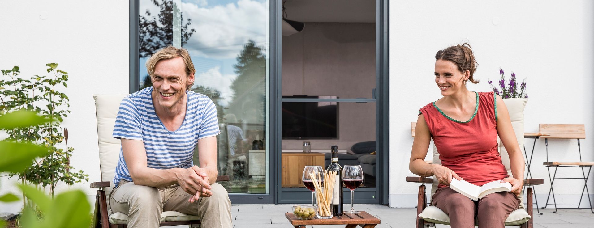 Terrasse mit geöffneter Schiebetür und integriertem Insektenschutz – entspanntes Wohnen mit frischer Luft