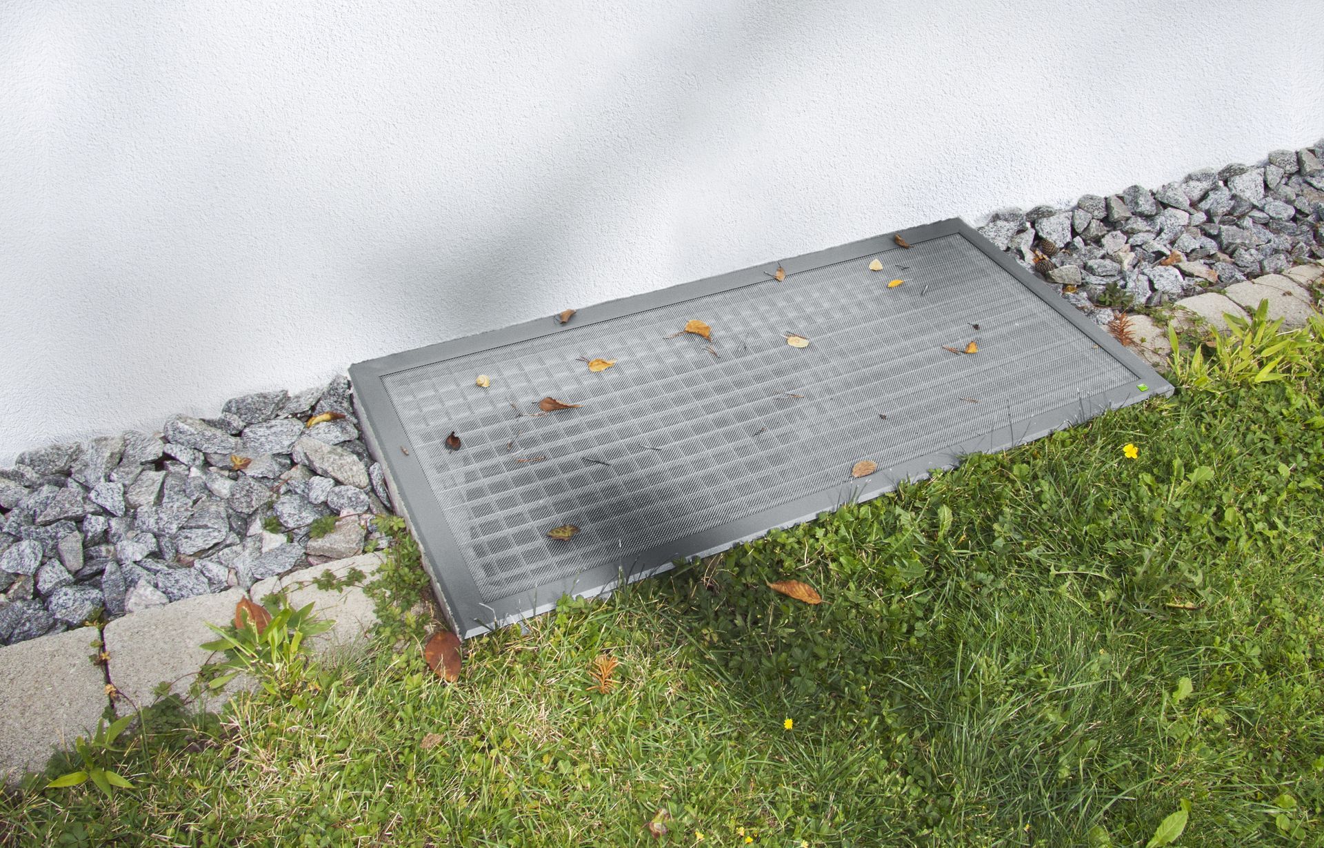 Lichtschachtabdeckung „Lisa“ von Neher im Gartenbereich – flache, begehbare Abdeckung mit robustem Edelstahlgewebe, schützt Kellerschächte zuverlässig vor Laub, Schmutz und Insekten.