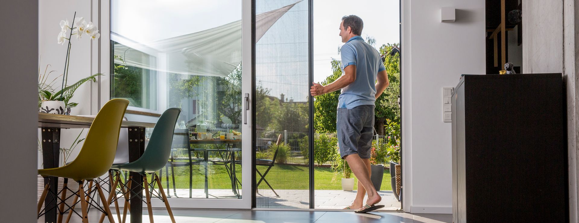 Puerta mosquitera plisada de ISK Systeme instalada en acceso a terraza – sistema plisado Neher compacto que ofrece paso cómodo, ventilación natural y protección eficaz contra insectos.