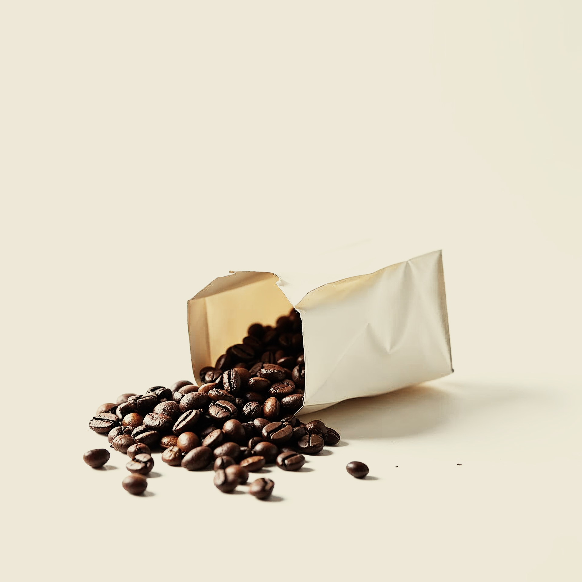 Eine offen umgefallene Kaffeetüte, aus der geröstete Covvi Premium Kaffeebohnen geschüttet wurden