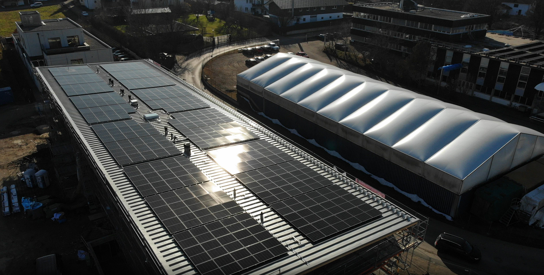 PV-Anlage mit 146,7 kWp auf dem Dach des Ärzte- und Gewerbehauses Rimsting, Luftaufnahme mit Solarmodulen.