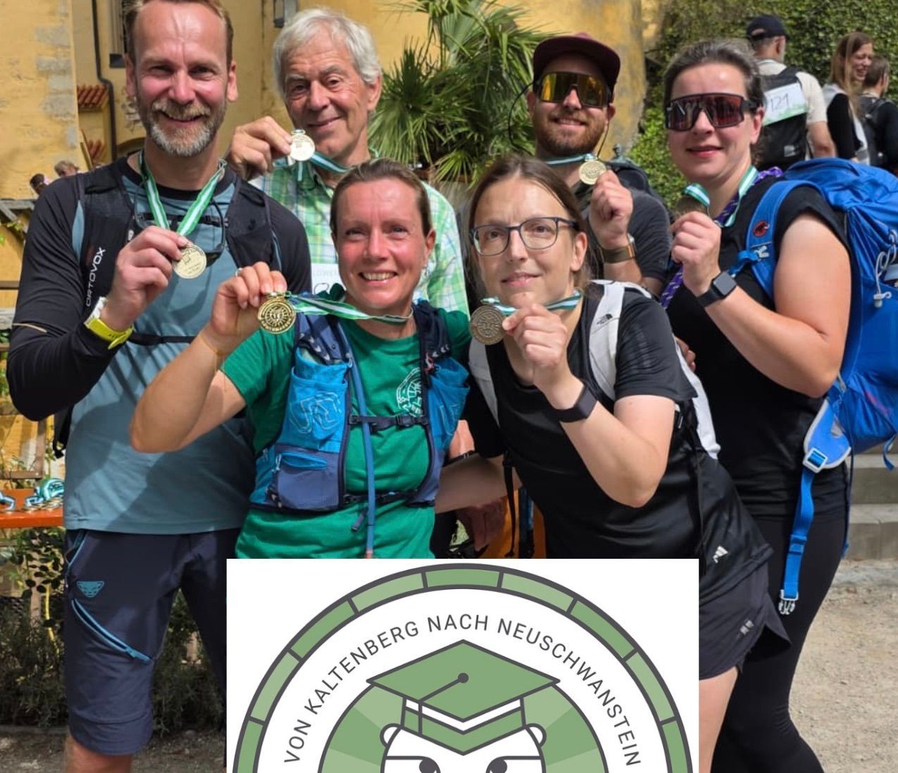 Sechs Teilnehmer des Löwenmarschs posieren vor einem Schloss und zeigen ihre Medaillen.