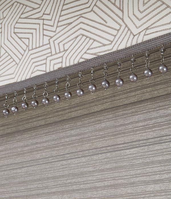 Custom hobbled relaxed soft roman shade with beading trim along the bottom