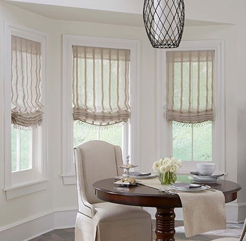 Custom hobbled relaxed soft roman shade with beading trim along the bottom