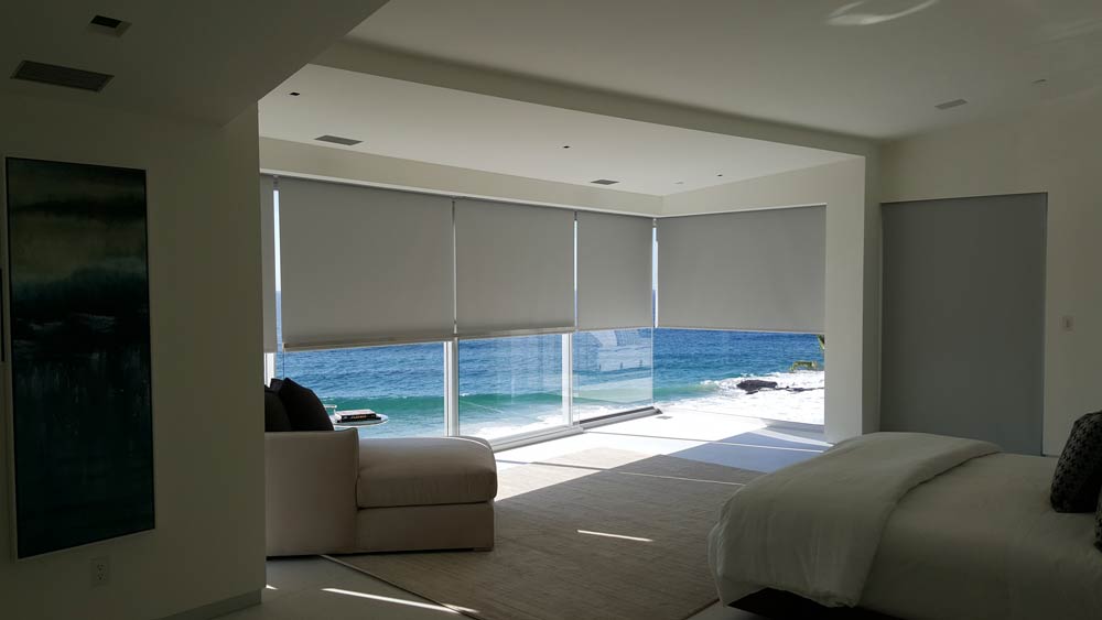 Motorized blackout roller shade in modern beachfront bedroom Irvine