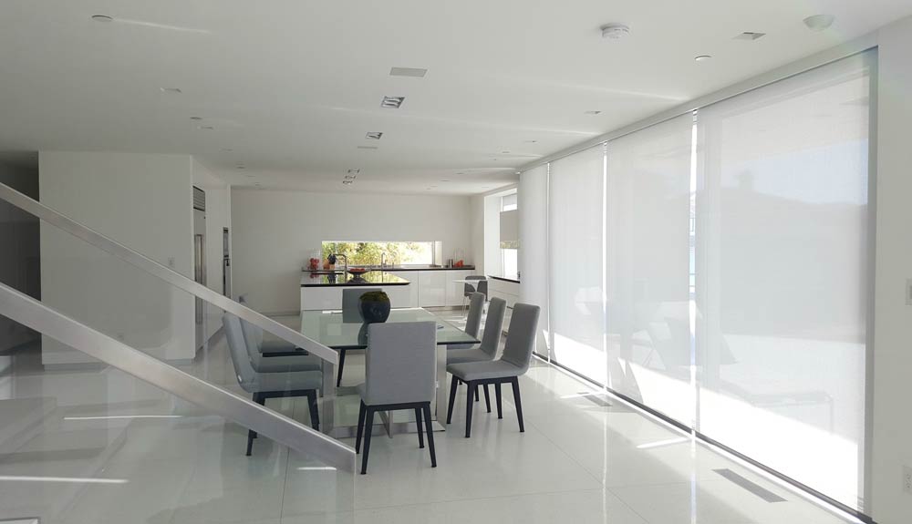 Motorized roller shade in modern kitchen dining room with staircase Irvine