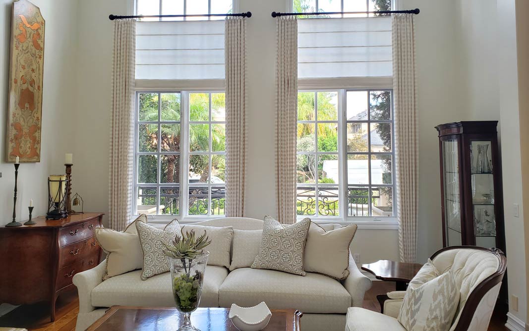 Motorized Hunter Douglas roman shade with stationary drapery panels in traditional beige white living room Irvine