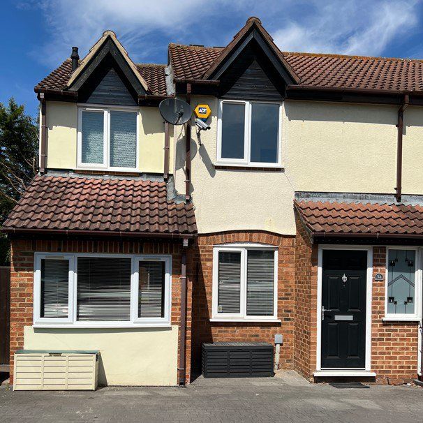 cream house with brick design and black door