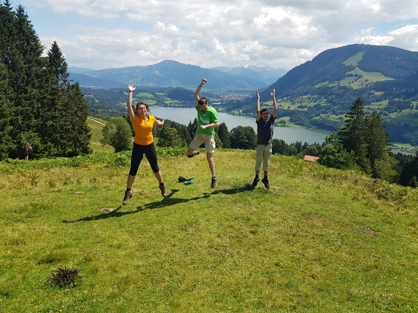 Drei Tourenteilnehmer springen vor Freude in die Luft.