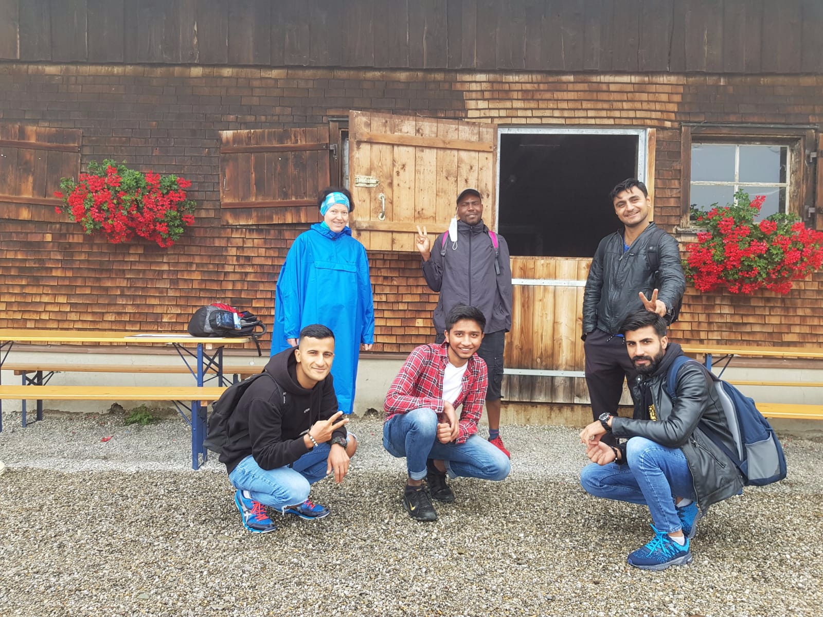 Das Bild zeigt sechs lachende Menschen vor einer Alphütte.