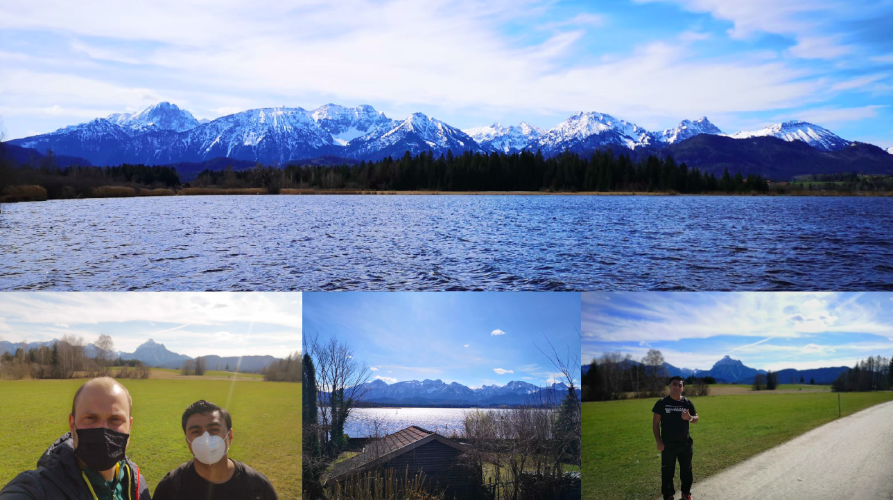 Über dem Hopfensee erstreckt sich ein blauer Himmel, man sieht die Berge im Hintergrund.