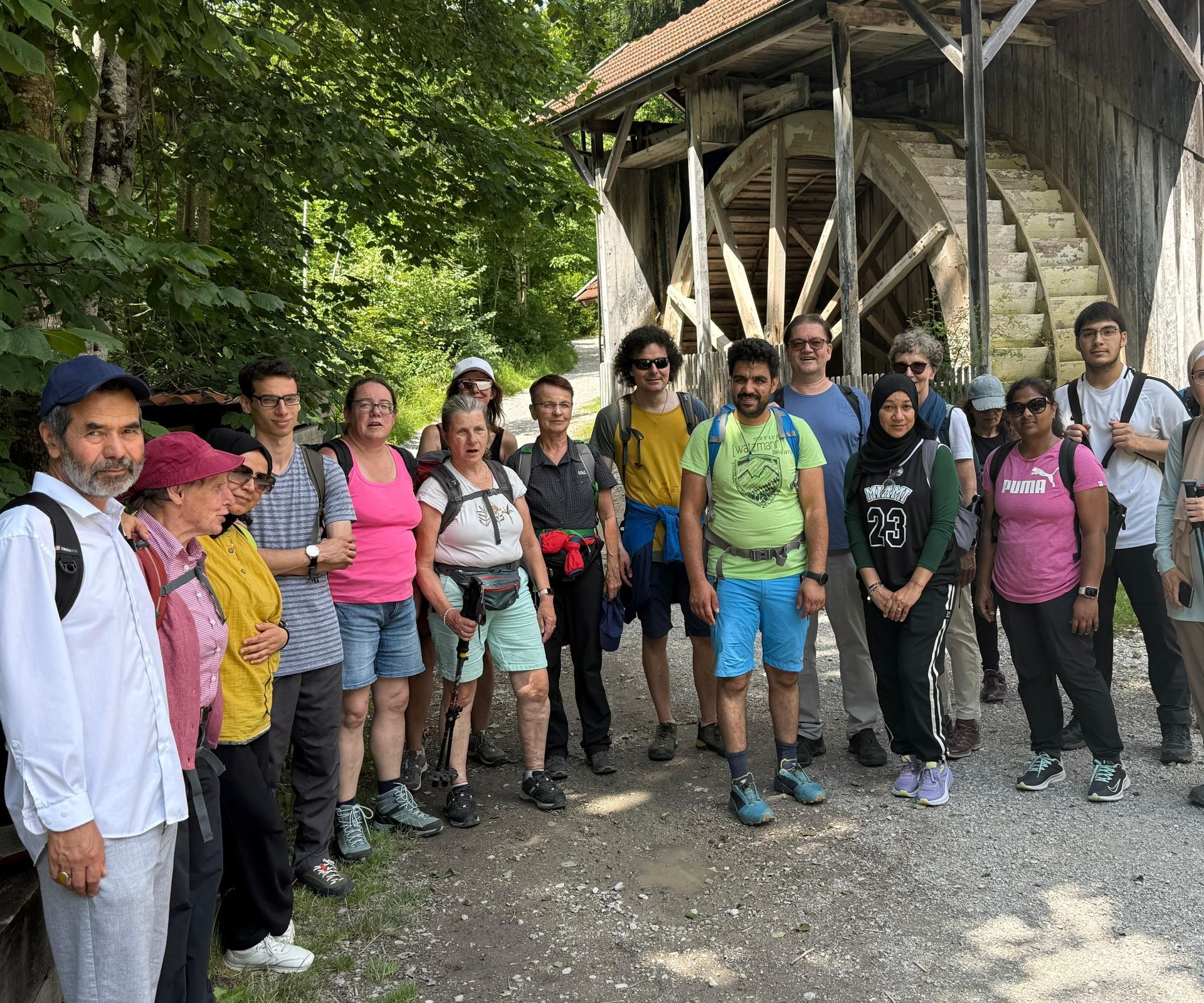 Gruppe von Menschen vor einem alten Mühlrad