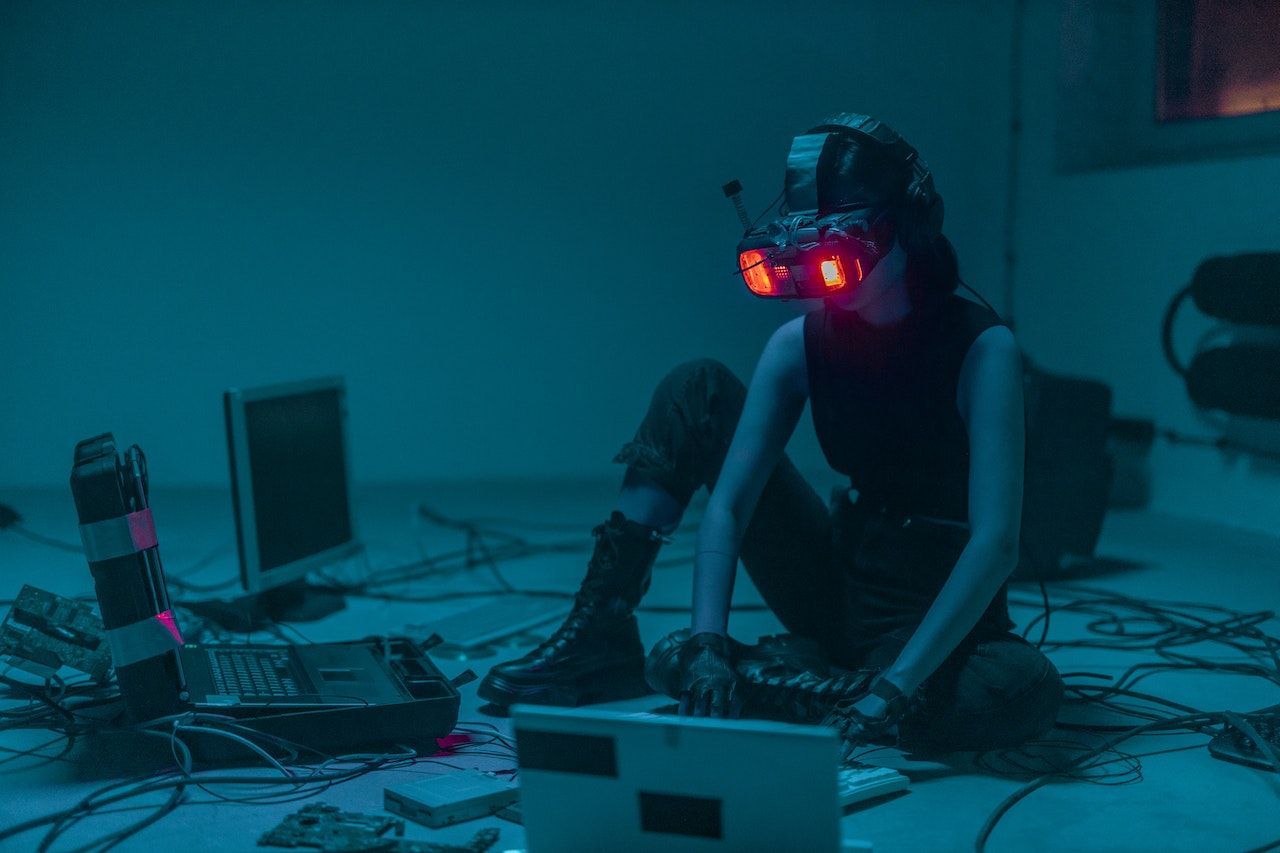 A person sitting on the floor with infrared goggles using a computer to combat cyber security war