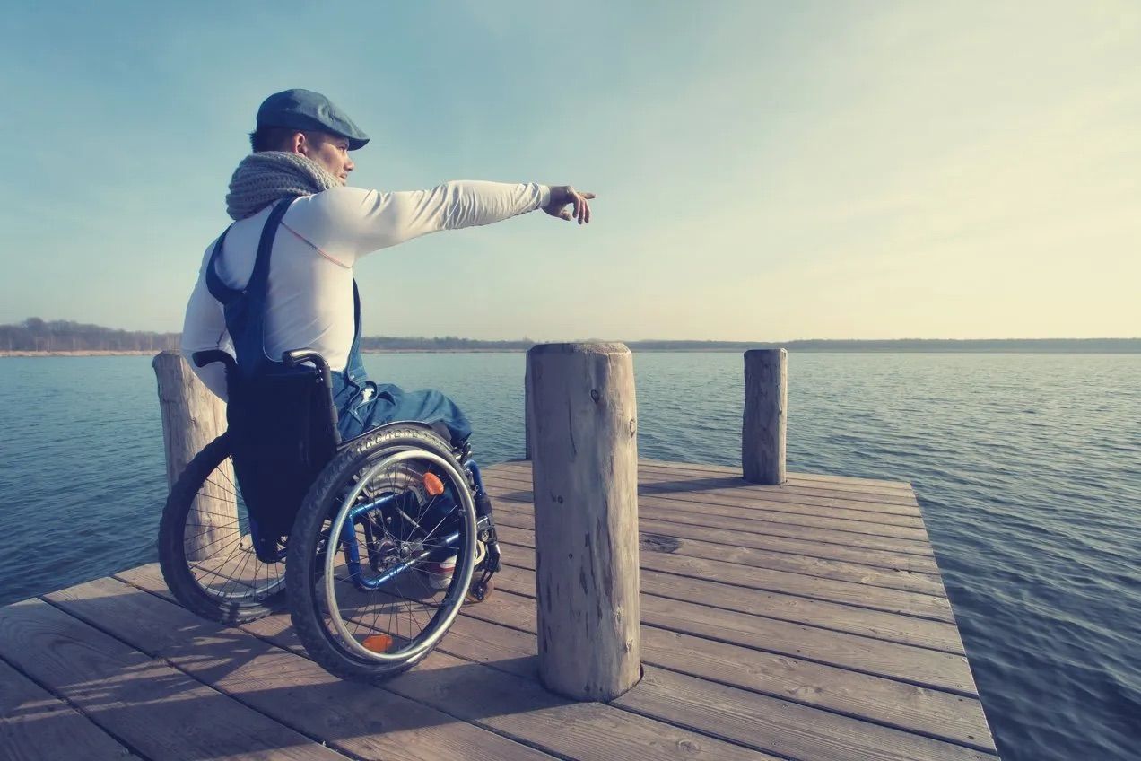 Person im Rollstuhl mit James Notrufuhr von Vitatel für mehr Sicherheit