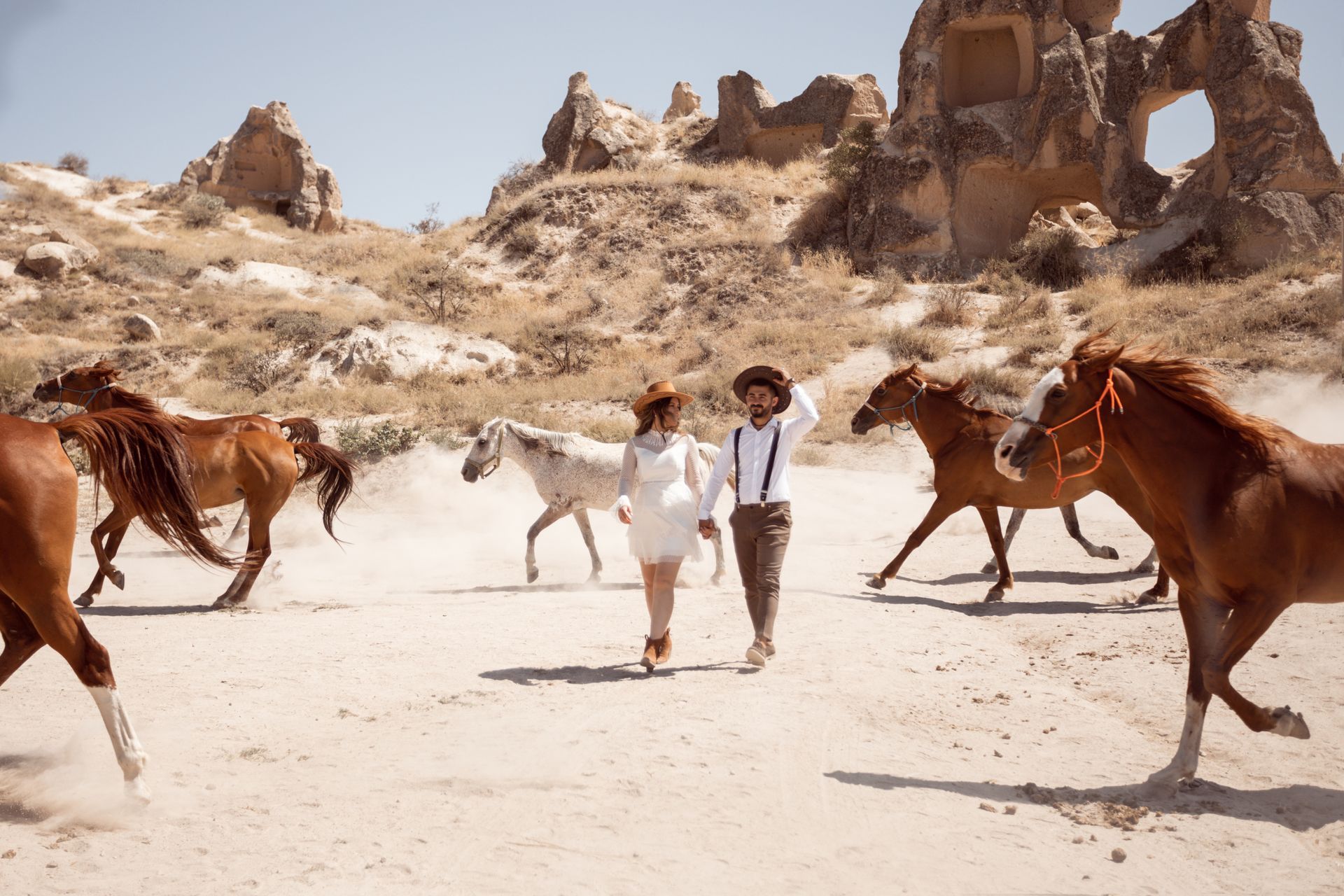 Pferde rennen durch das Bild und ein Paar läuft mittendurch