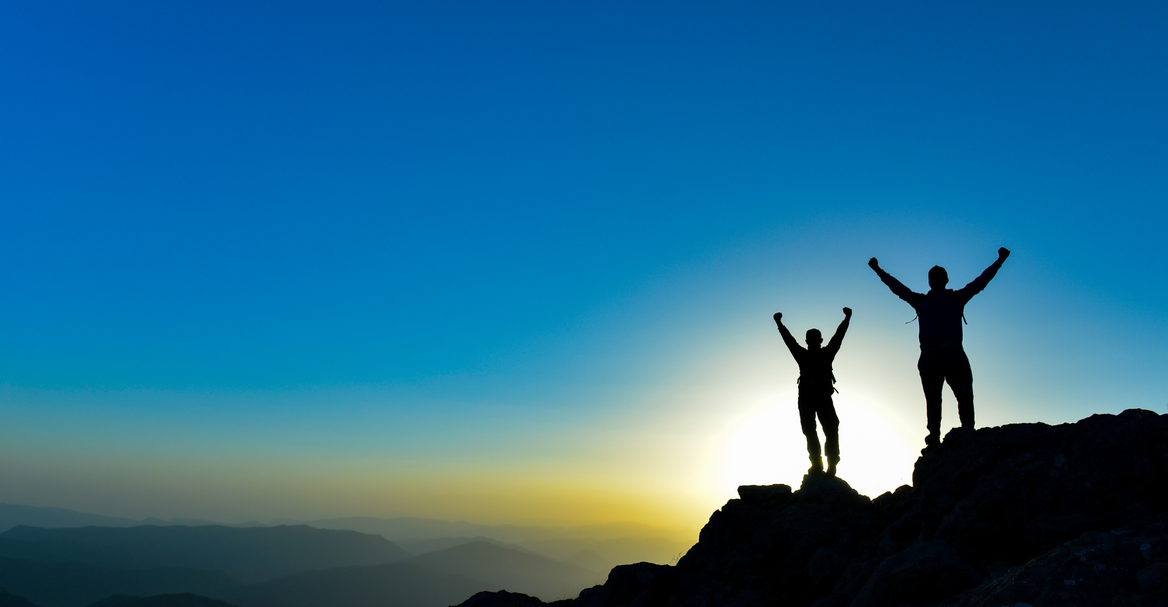 two people at the top of a mountain