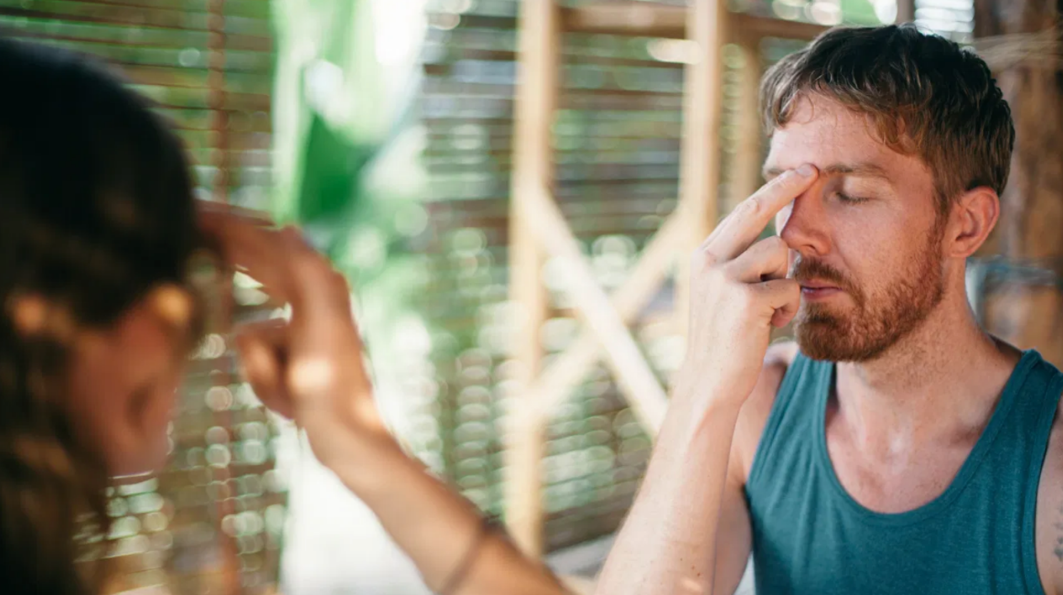 Man with eyes closed tapping his forehead