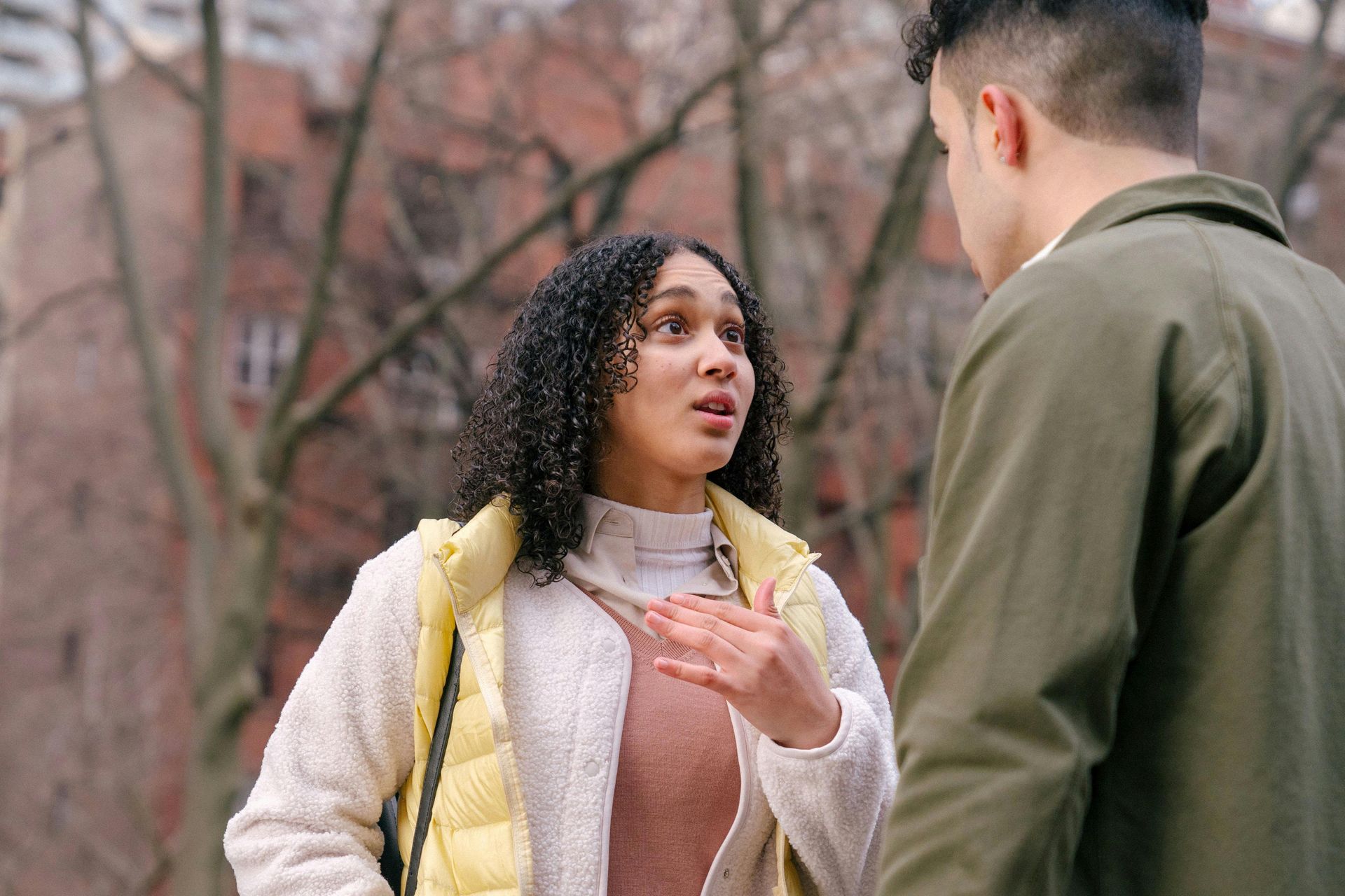 Couple talking to each other outside by trees