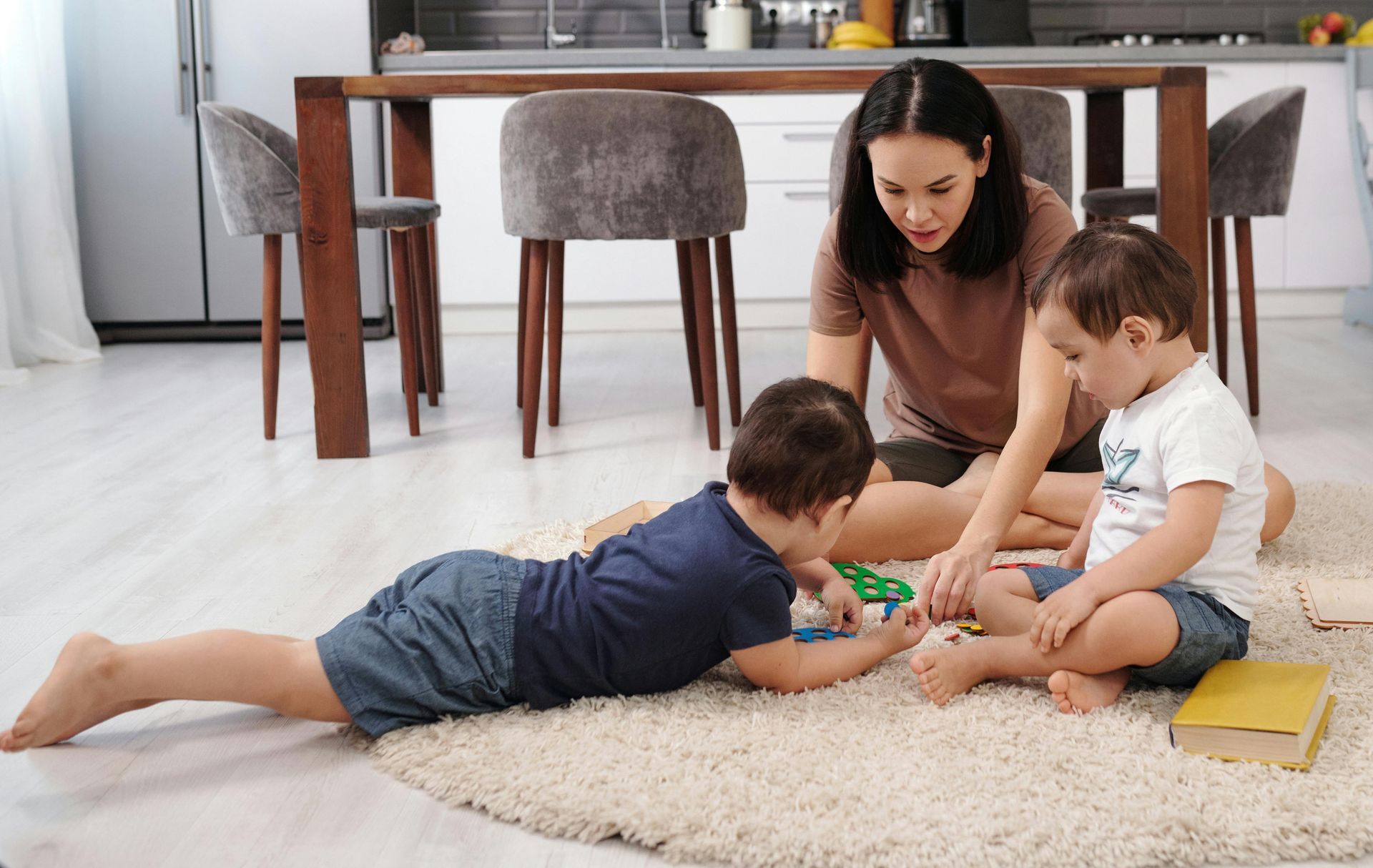 mum playing on floor with two children