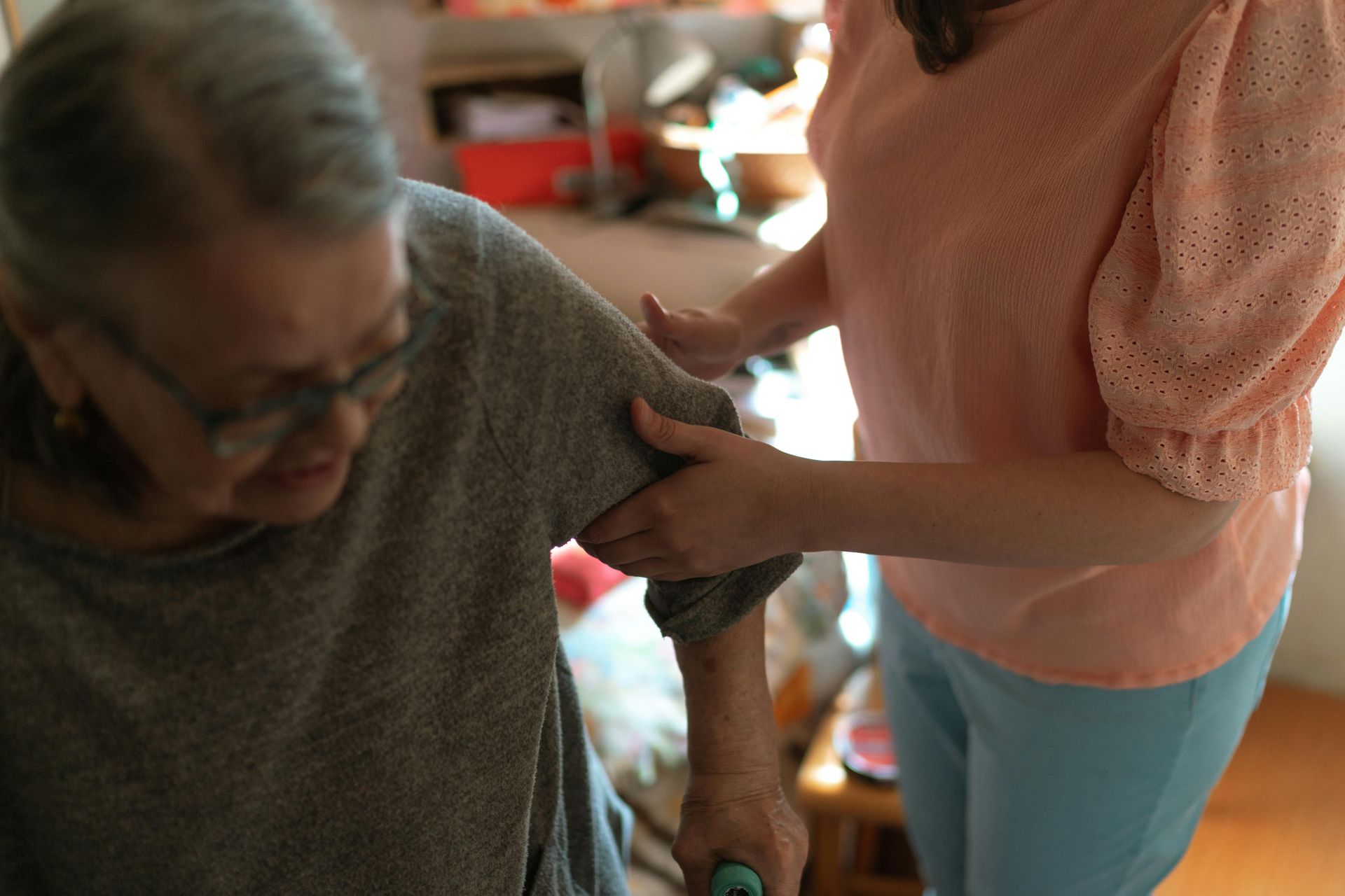 Woman helping another woman to sit down